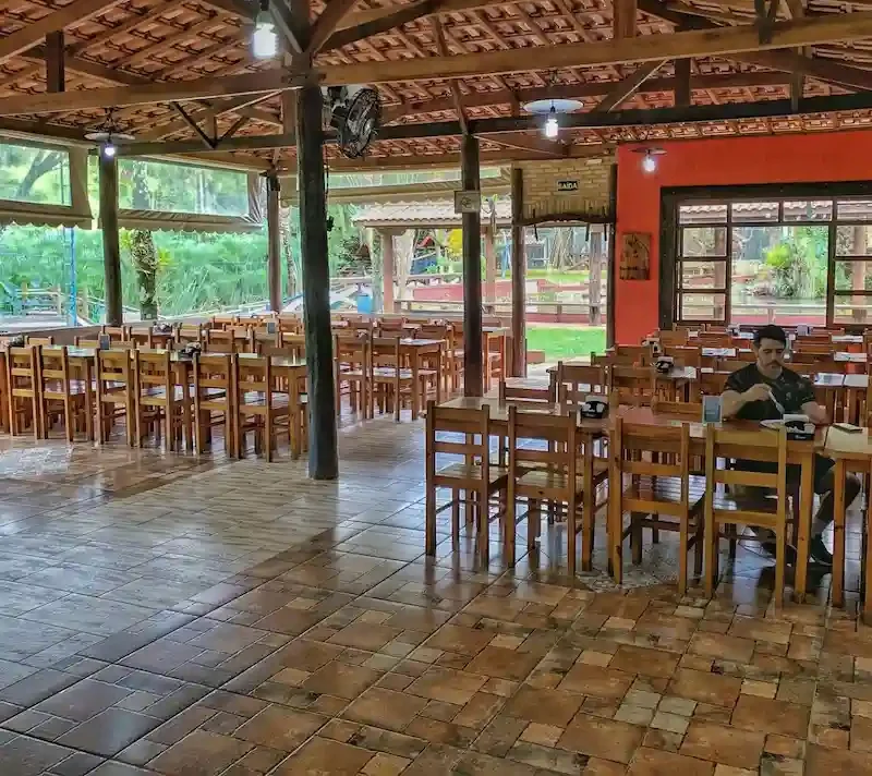 Área interna com mesas de madeira — Sabor do Campo Taubaté